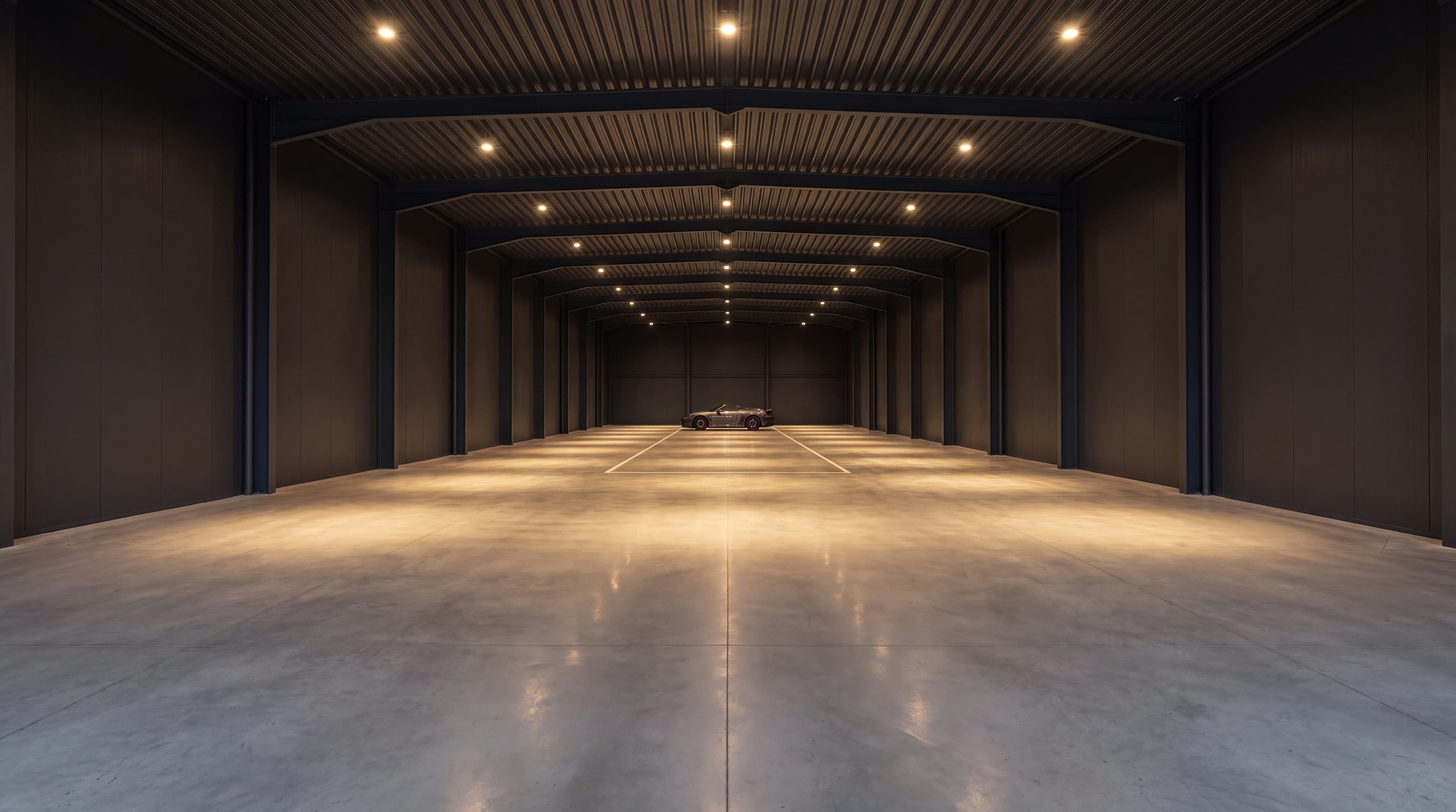 Galeria vasta e quase vazia da Vault 620, com focos de luz quente e a silhueta distante de um único automóvel