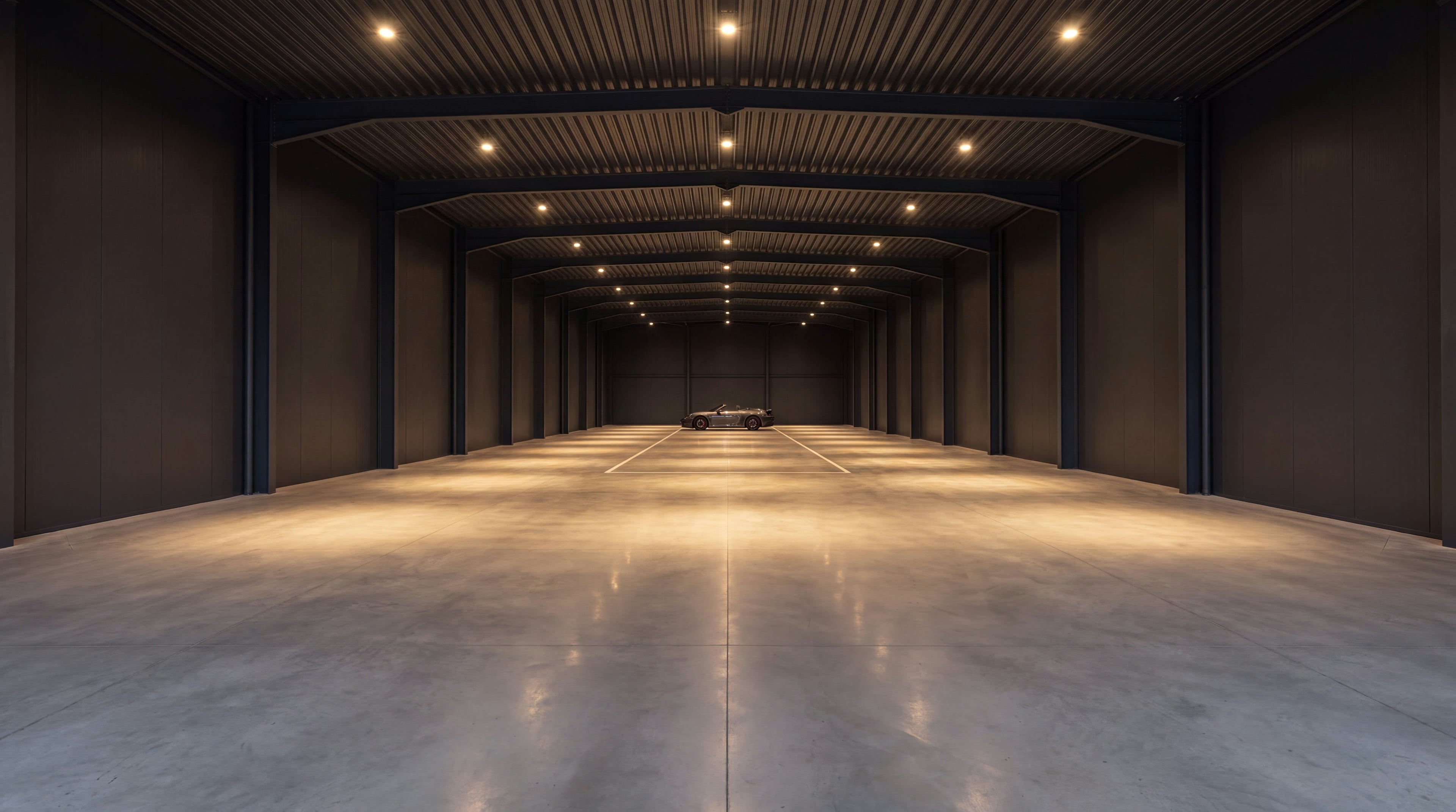 Galeria vasta e quase vazia da Vault 620, com focos de luz quente e a silhueta distante de um único automóvel