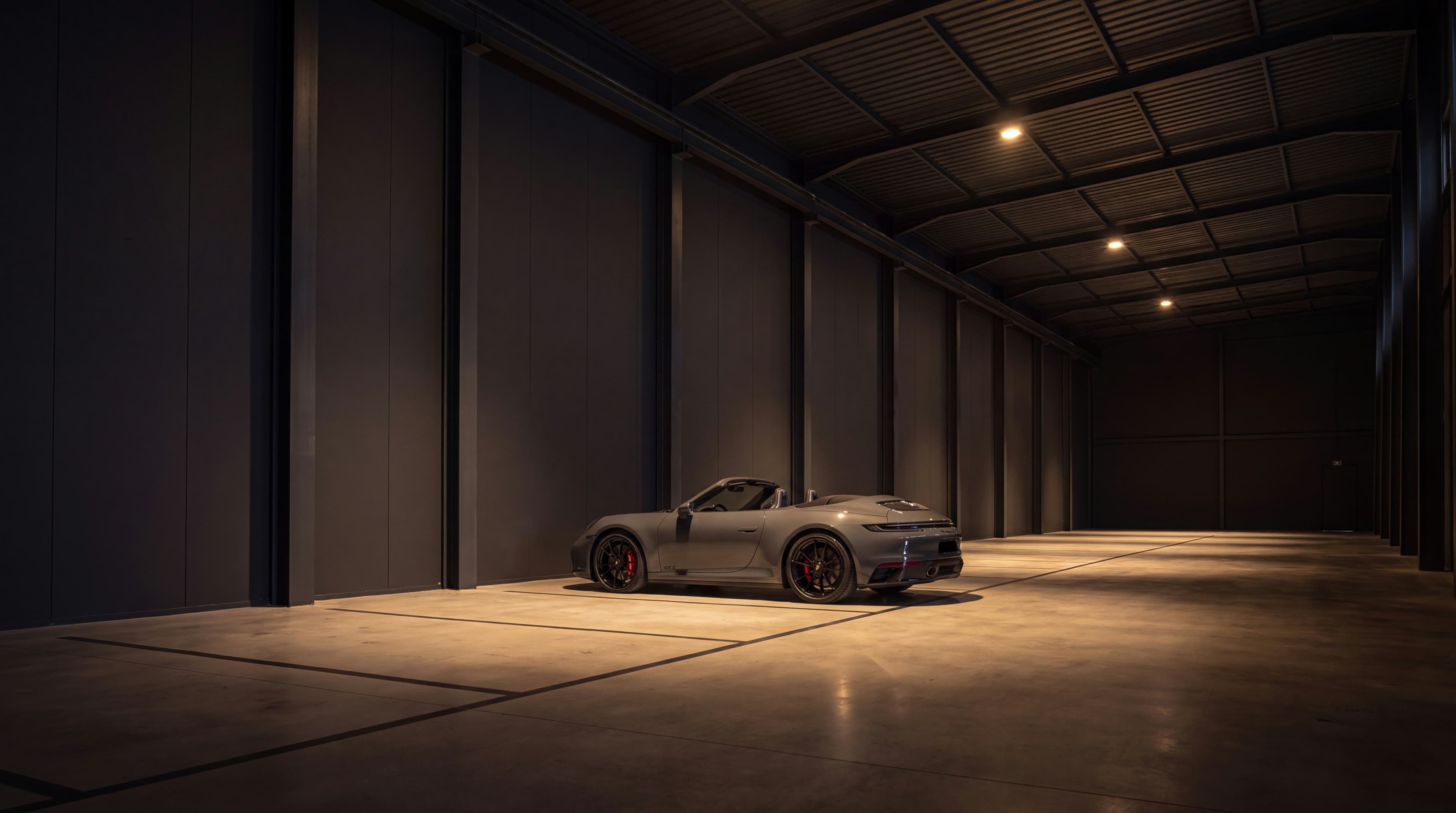 Porsche 911 cinzento exposto sozinho no espaço escuro de galeria da instalação de preservação Vault 620