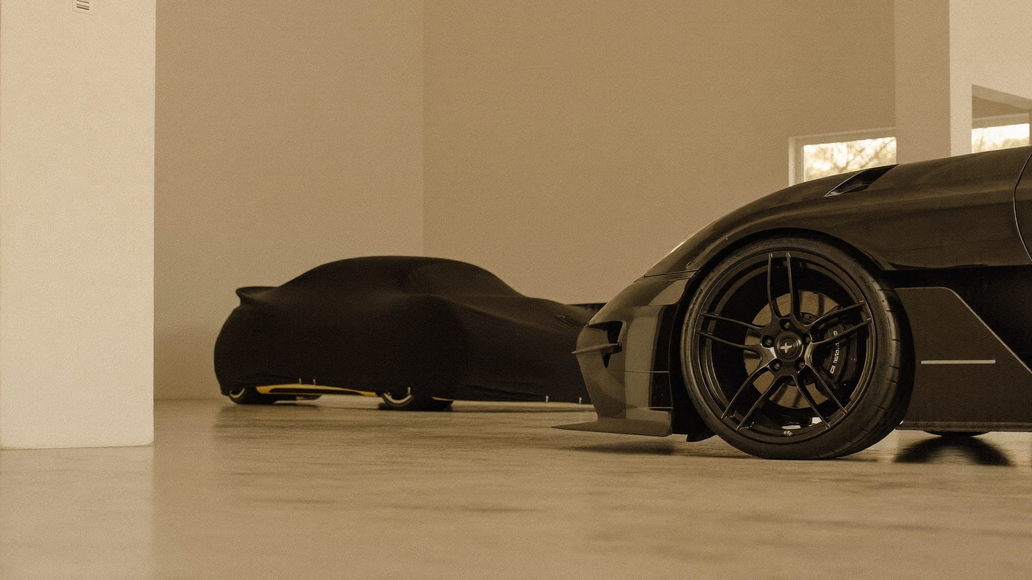 Showroom-finish storage environment at Vault 620 with a covered sports car and detailed alloy wheel in warm daylight